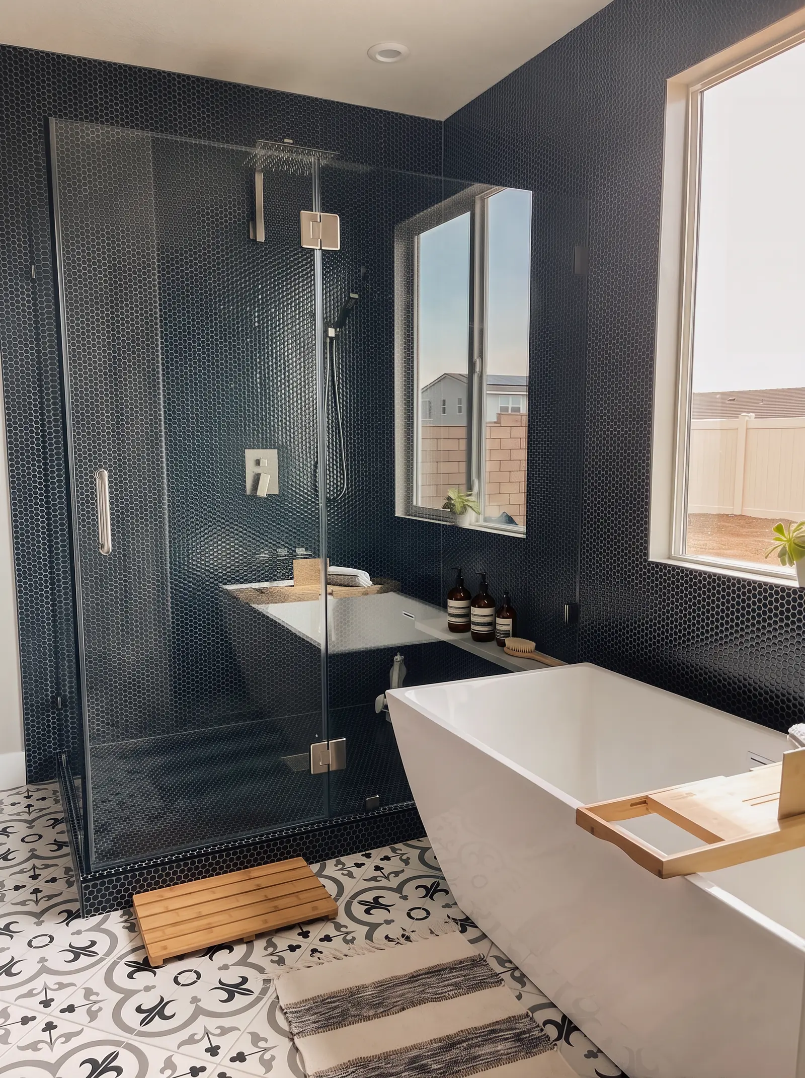 Primary bathroom remodel with navy hex tile, glass shower and freestanding tub